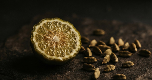 Bergamot and cardamom on dark stone